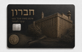 Metal credit card with a detailed engraving of ancient fortified stone walls and structures of old Jerusalem with Hebrew lettering